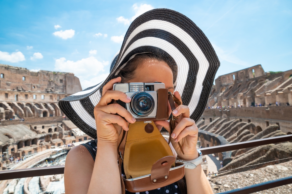 Žena fotografující památky v římském Koloseu.