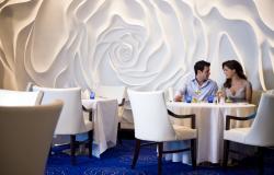 Celebrity Solstice - Celebrity Cruises - originální dekor bílé růže na zdi a dva lidé sedící v Blu 