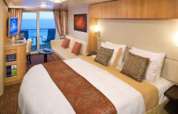 Celebrity Solstice - Celebrity Cruises - ustlaná manželská postel v balkonové kajutě na lodi
