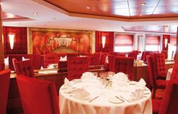 MSC Poesia - MSC Cruises - jídelní stůl a červené luxusní potahy na jídelních židlích