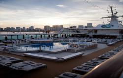 Azamara Journey - Azamara Club Cruises - bazén a lehátka na horní palubě lodi a v pozadí městské mrakodrapy