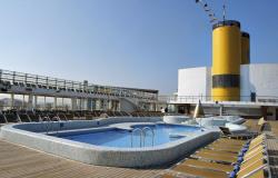 Costa Victoria - Costa Cruises - bazén na hlavní palubě, lehátka a žlutý komín v pozadí